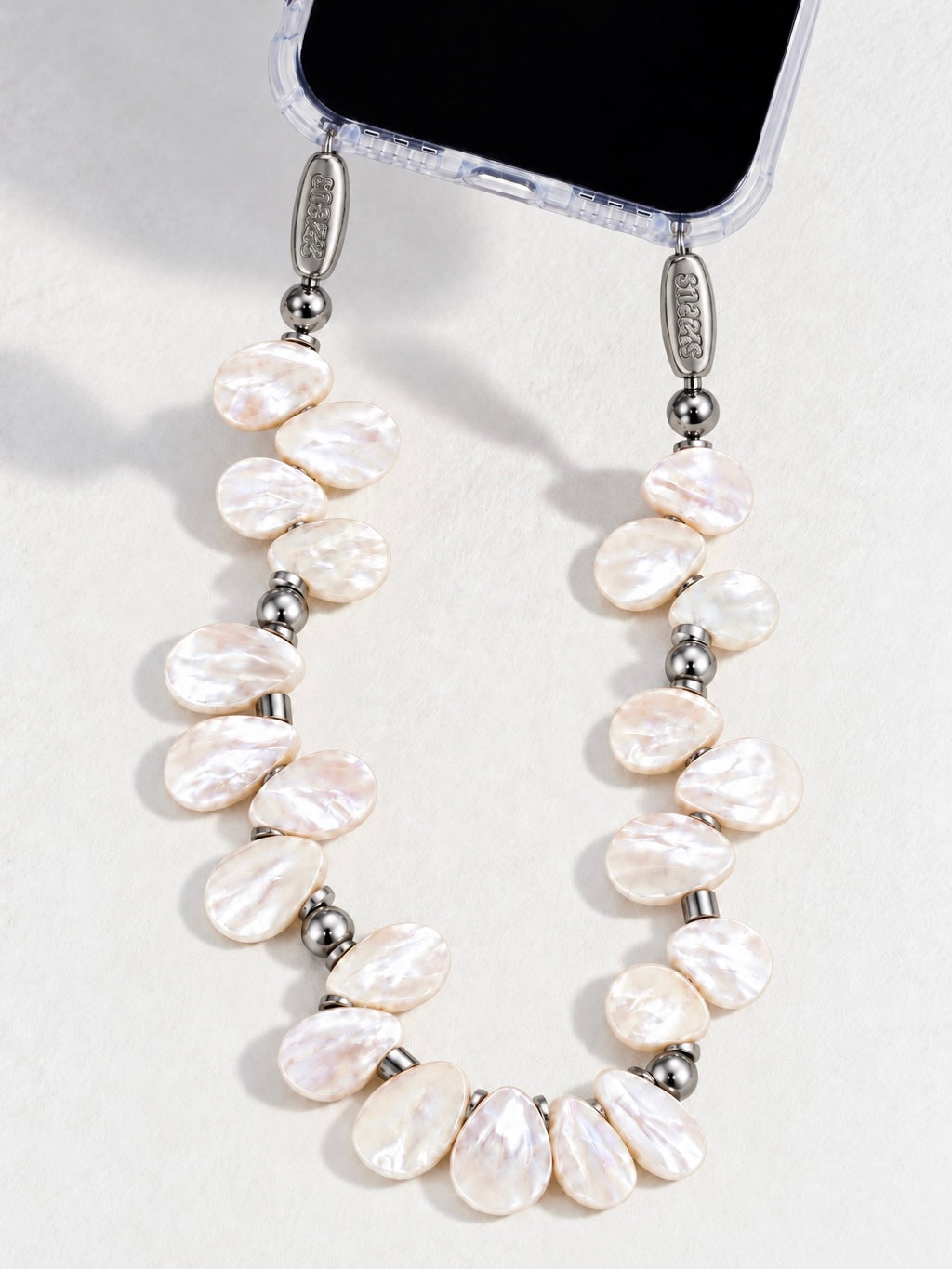 Petal Pearl phone chain by Snazz with iridescent natural pearls and silver beads on a clear iPhone case